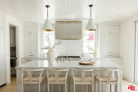 a kitchen with a dining table chairs and white cabinets