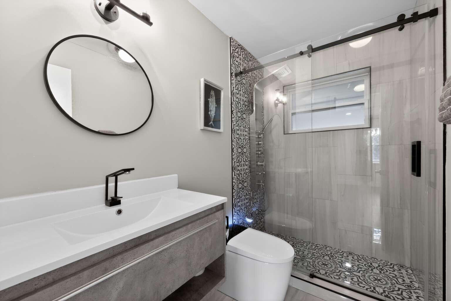 1773 Ocala Road North Palm Beach, FL 33408 - Photo 30 of 47 a bathroom with a sink a mirror a toilet and shower