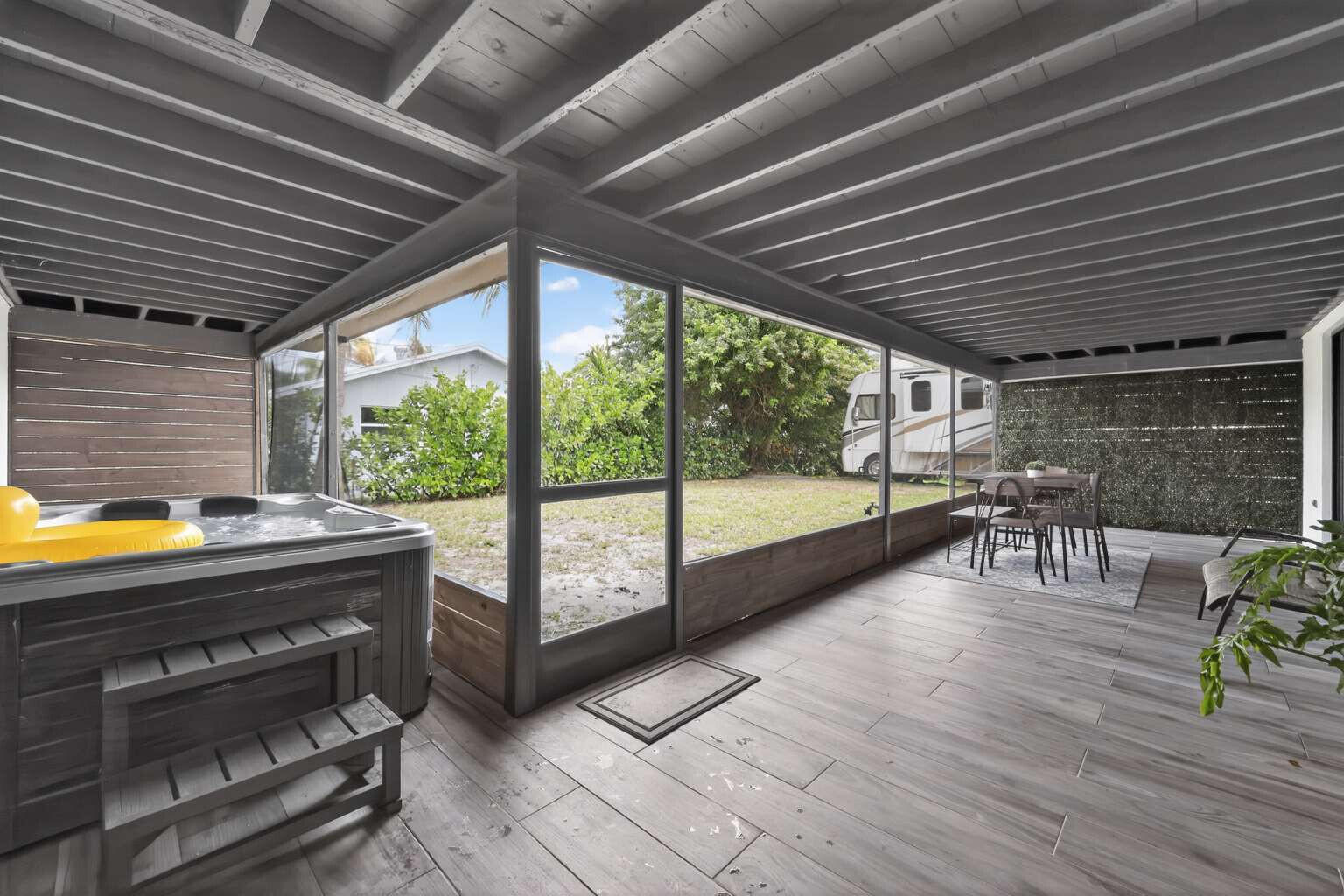 1773 Ocala Road North Palm Beach, FL 33408 - Photo 36 of 47 a view of a patio with table and chairs a barbeque with wooden floor and roof with a floor to ceiling window