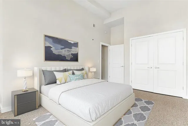 a bedroom with a large bed and a lamp