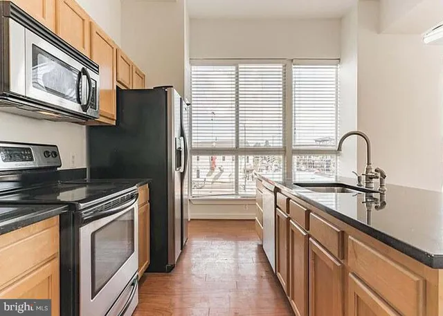 a kitchen with stainless steel appliances a stove sink and cabinets