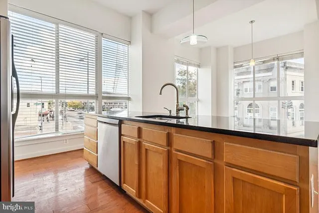 a kitchen with stainless steel appliances granite countertop a stove a sink and white cabinets