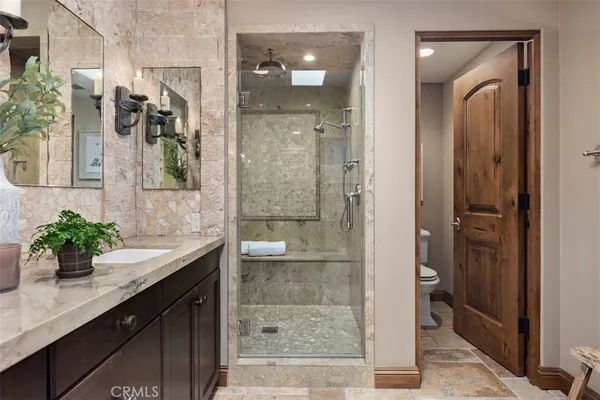 a bathroom with a granite countertop shower sink and mirror