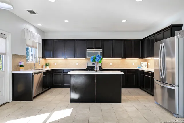 a kitchen with granite countertop a refrigerator and a sink