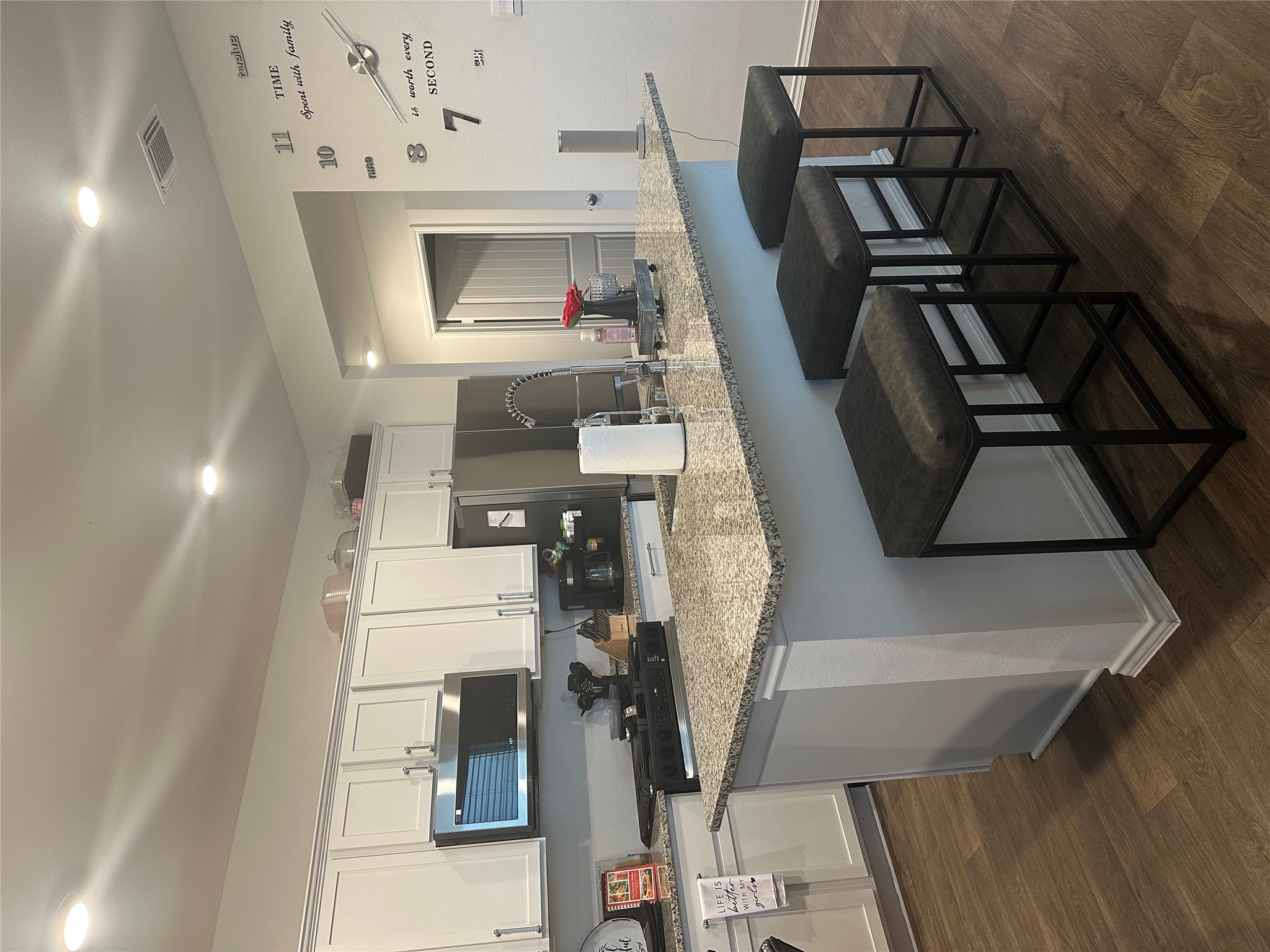 519 Sandringham Loop Kyle, TX 78640 - Photo 13 of 26 Kitchen featuring a breakfast bar area, light stone countertops, dark wood-type flooring, and recessed lighting