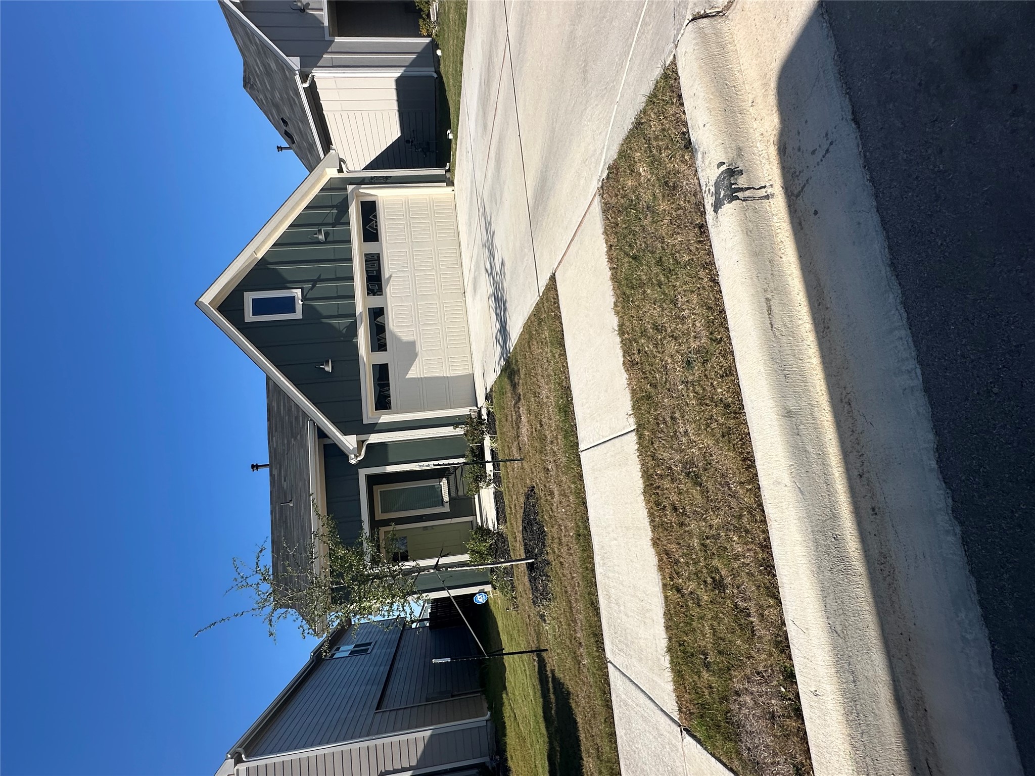519 Sandringham Loop Kyle, TX 78640 - Photo 26 of 26 View of front facade with board and batten siding, driveway, and a garage