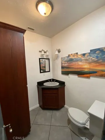 an empty room with wooden floor chandelier fan and windows