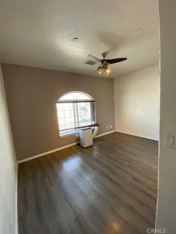 an empty room with wooden floor and window