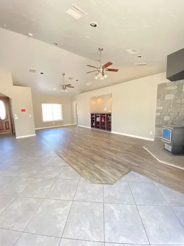 a view of an empty room and kitchen view