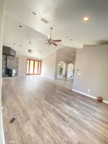 a view of an empty room with a window and a fireplace