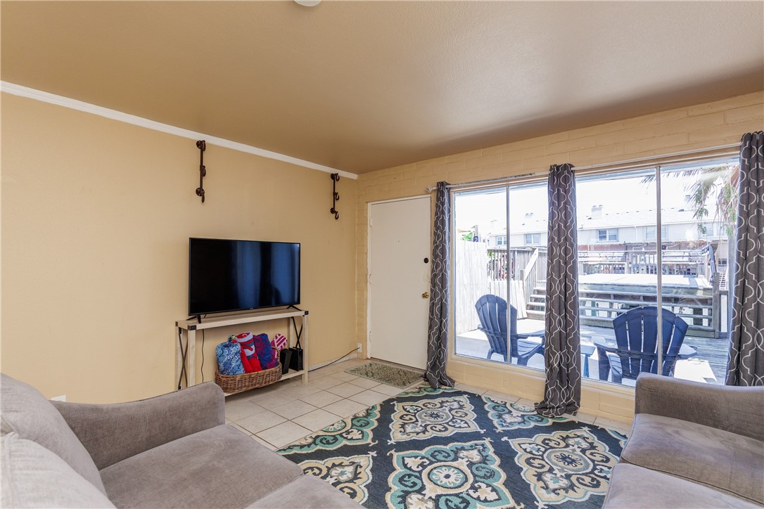 15432 Salt Cay Court, Unit 101 Corpus Christi, TX 78418 - Photo 11 of 37 a living room with furniture and a flat screen tv