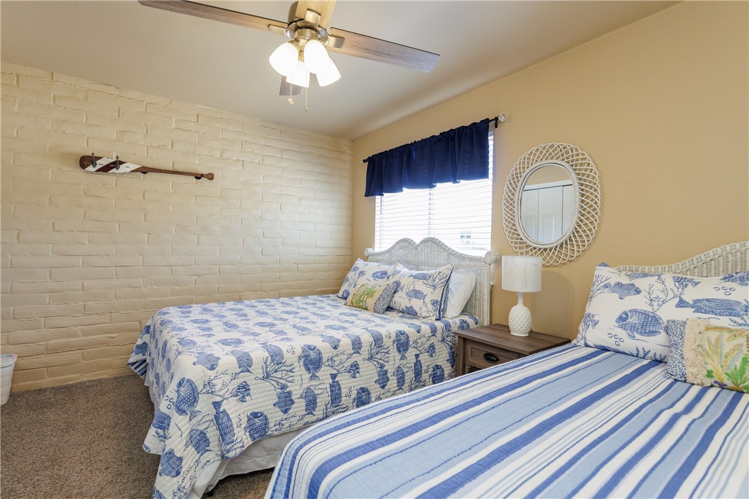 15432 Salt Cay Court, Unit 101 Corpus Christi, TX 78418 - Photo 17 of 37 a bedroom with a bed and a chandelier