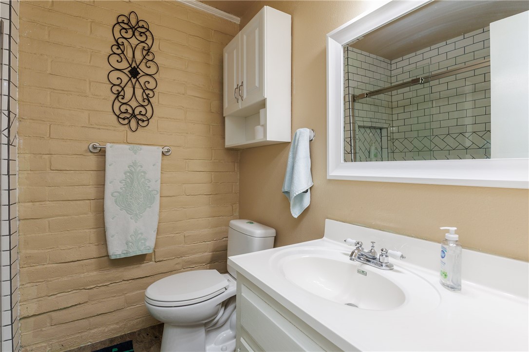15432 Salt Cay Court, Unit 101 Corpus Christi, TX 78418 - Photo 18 of 37 a bathroom with a sink toilet and a mirror