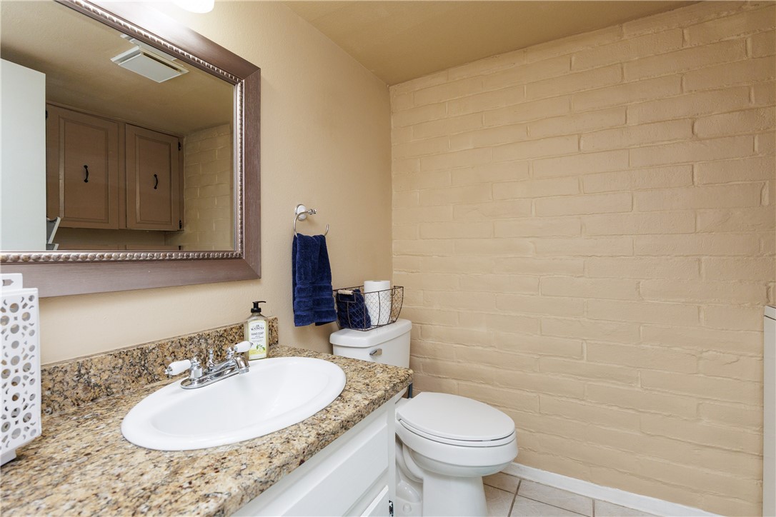 15432 Salt Cay Court, Unit 101 Corpus Christi, TX 78418 - Photo 20 of 37 a bathroom with a granite countertop sink toilet and a mirror