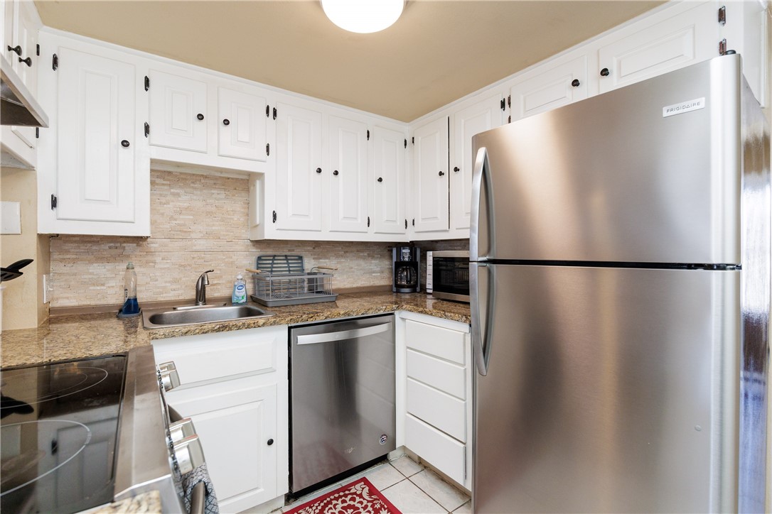 15432 Salt Cay Court, Unit 101 Corpus Christi, TX 78418 - Photo 4 of 37 a kitchen with cabinets and stainless steel appliances