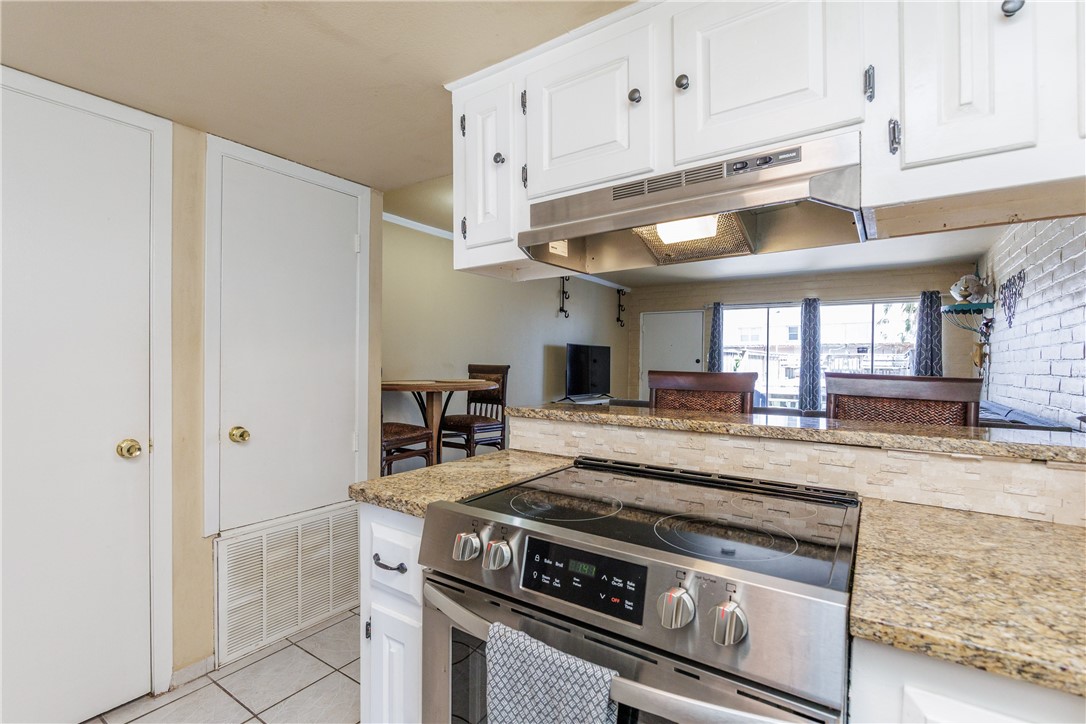15432 Salt Cay Court, Unit 101 Corpus Christi, TX 78418 - Photo 5 of 37 a kitchen with stainless steel appliances granite countertop a stove a refrigerator and a granite counter tops