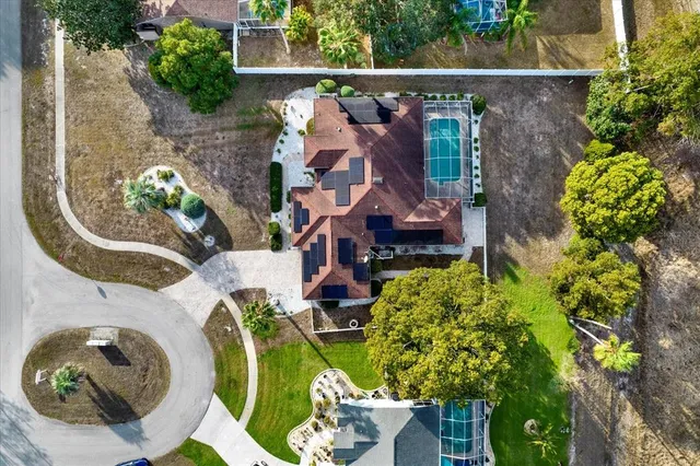 an aerial view of a house with a yard and lake view