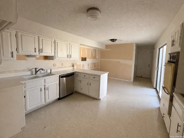 a kitchen with white cabinets and white appliances