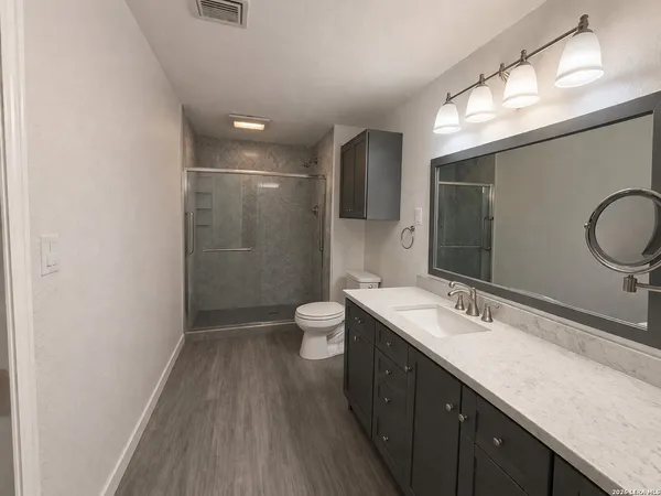 a bathroom with a double vanity sink toilet and a mirror