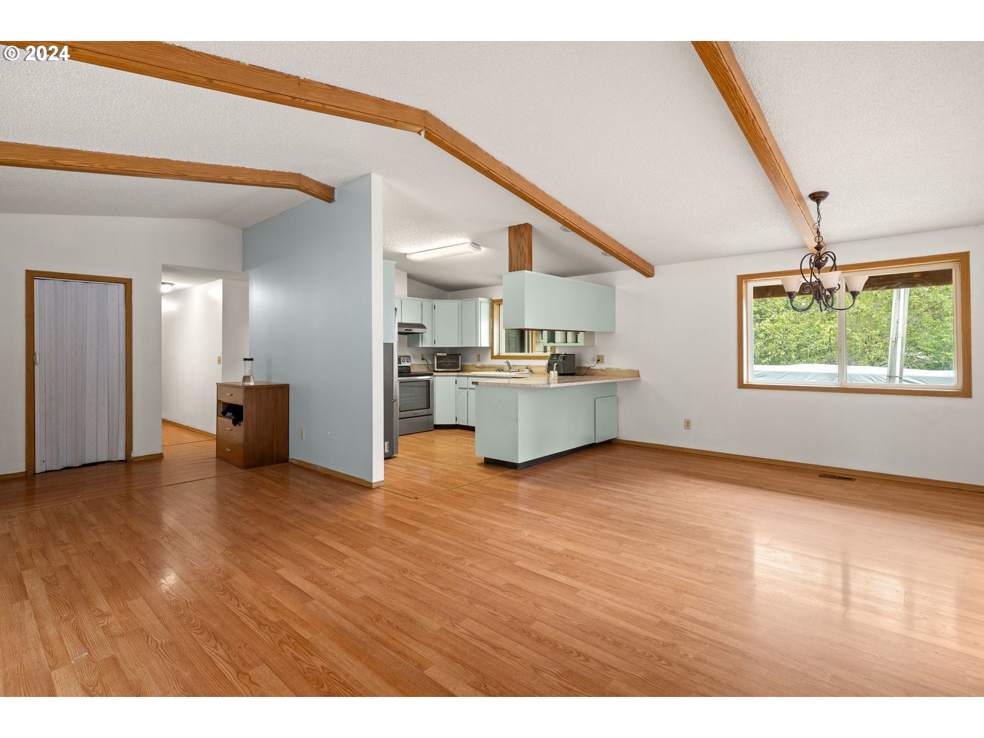 2701 Northeast 292nd Avenue Camas, WA 98607 - Photo 10 of 38 a view of a kitchen with a sink wooden cabinets and a living room