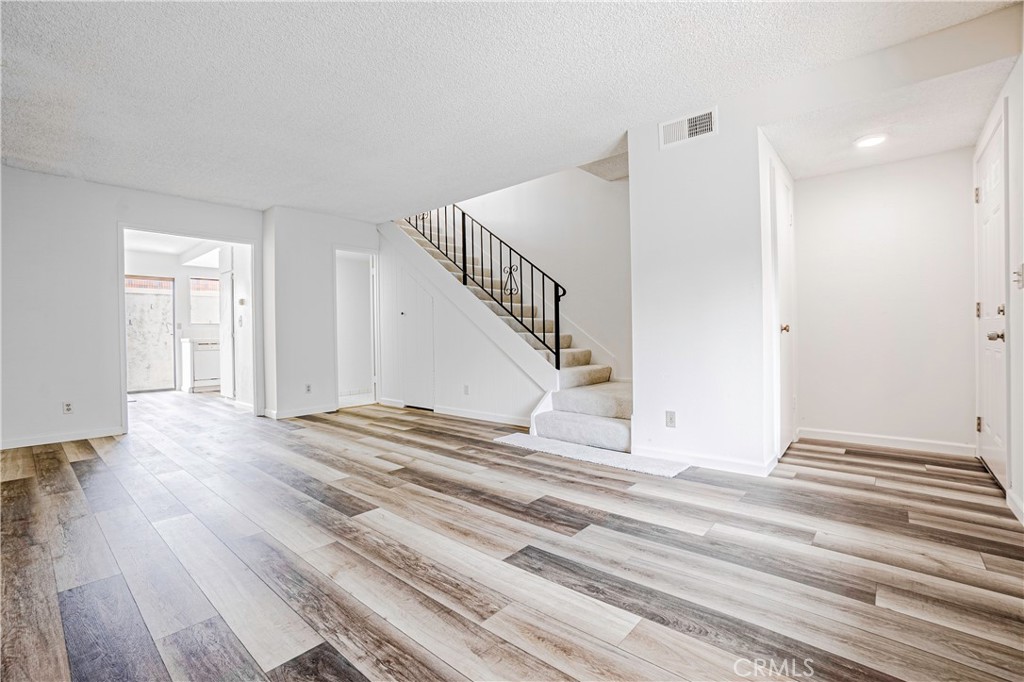 a view of a livingroom with wooden floor and stairs