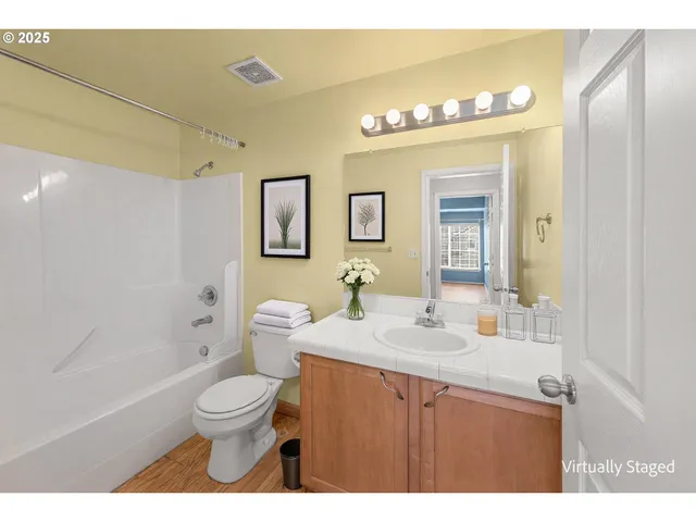 a bathroom with a sink a toilet a large mirror and shower