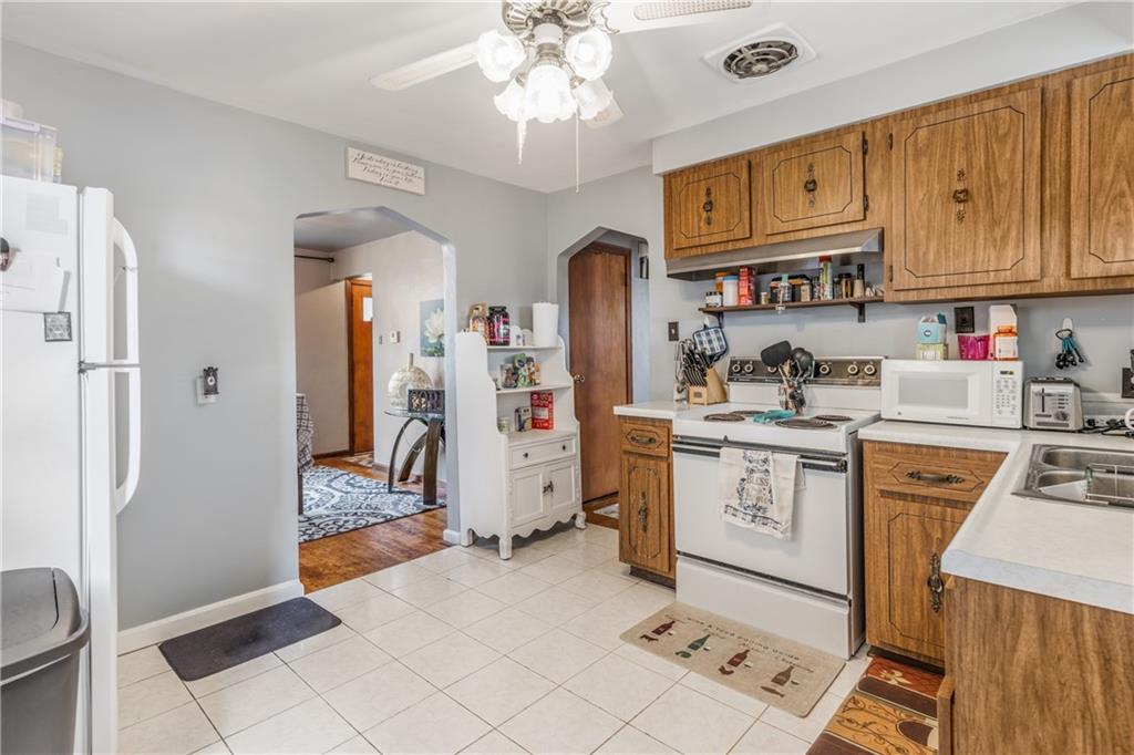 1308 Pine Hollow Road McKees Rocks, PA 15136 - Photo 5 of 25 a kitchen with stainless steel appliances granite countertop a refrigerator a stove a sink dishwasher and white cabinets with wooden floor