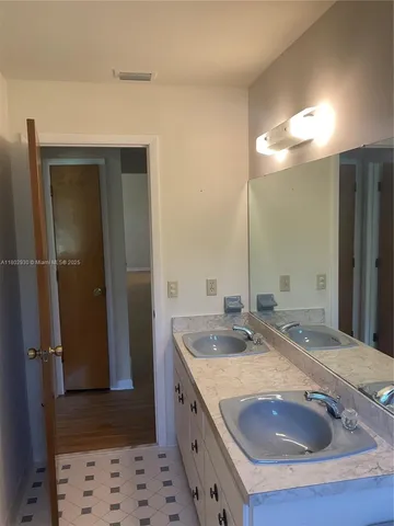 a bathroom with a granite countertop sink a mirror and shower