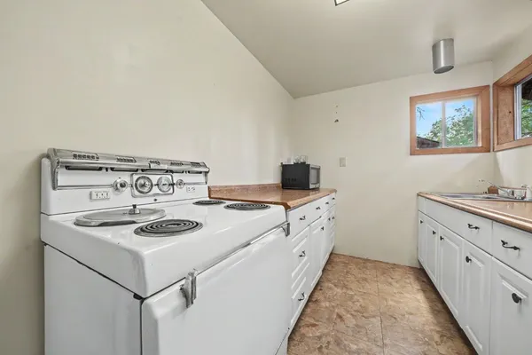 a kitchen with sink stove and cabinets