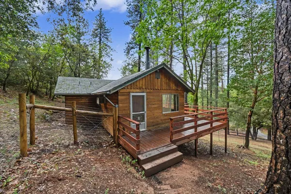 a view of a house with a yard and wooden fence