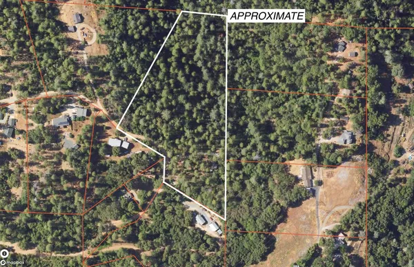 an aerial view of residential house with space and trees all around