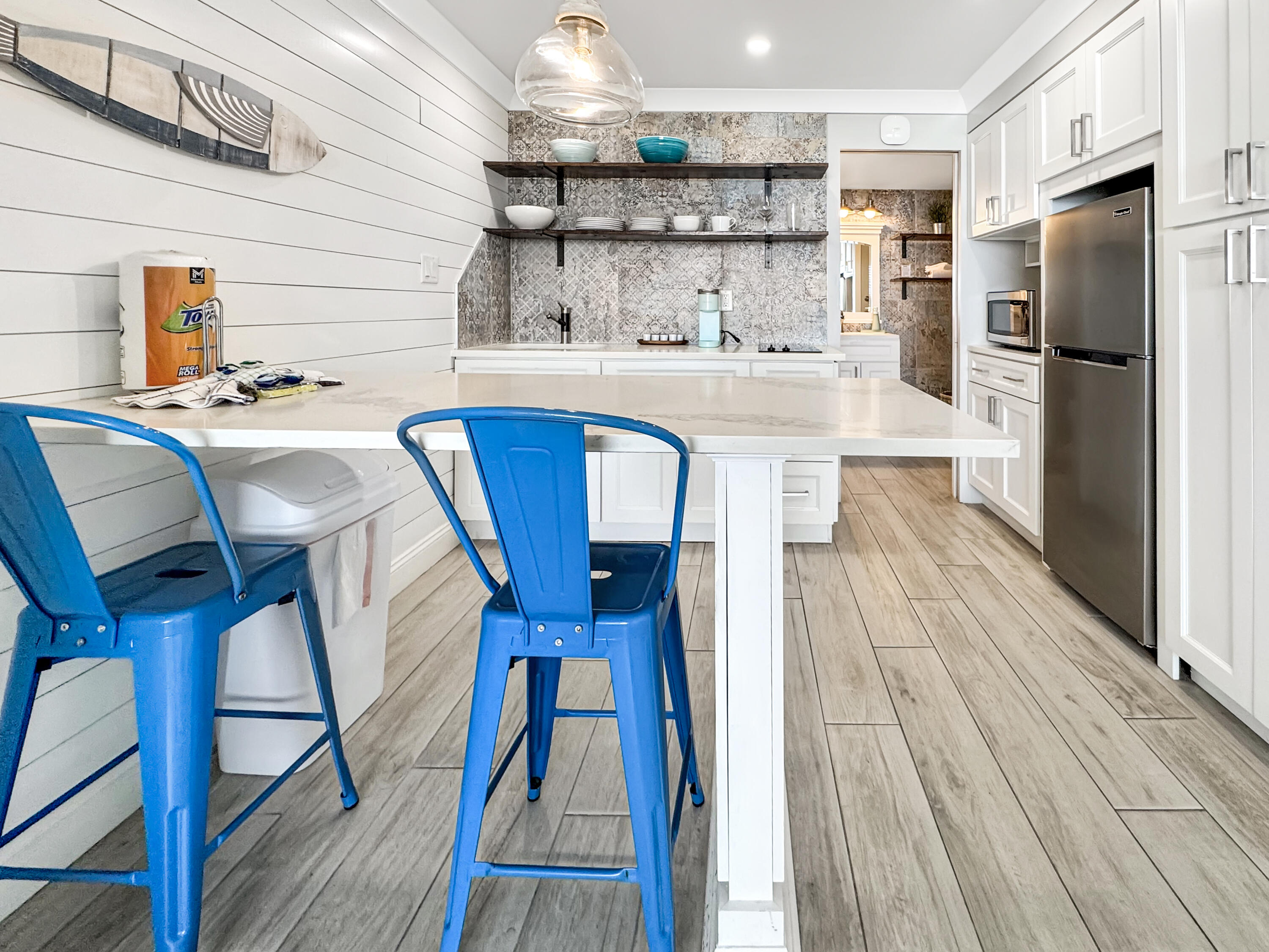 14401 Front Beach Road, Unit 221 Panama City Beach, FL 32413 - Photo 8 of 20 a kitchen with stainless steel appliances a dining table chairs refrigerator and sink
