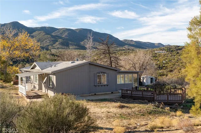 a view of a house with a yard and mountain in it