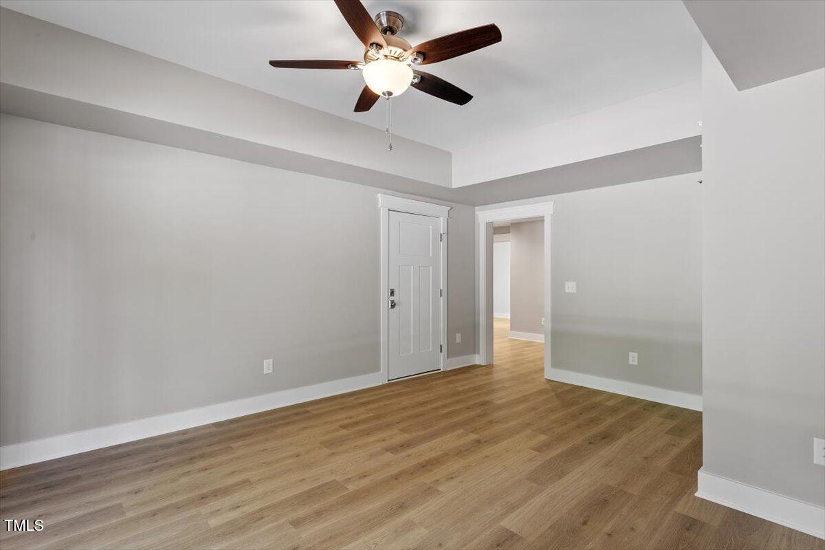 3932 Old Chapel Hill Road Durham, NC 27707 - Photo 41 of 46 an empty room with wooden floor and a ceiling fan