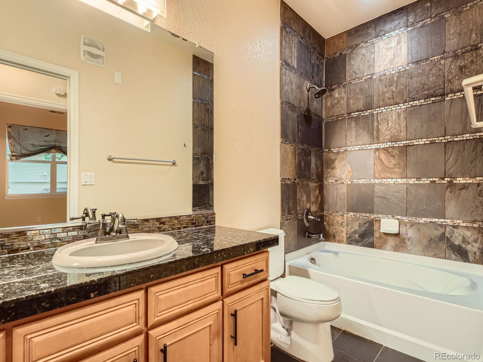 11316 Colony Circle Broomfield, CO 80021 - Photo 13 of 20 a bathroom with a granite countertop sink toilet and shower