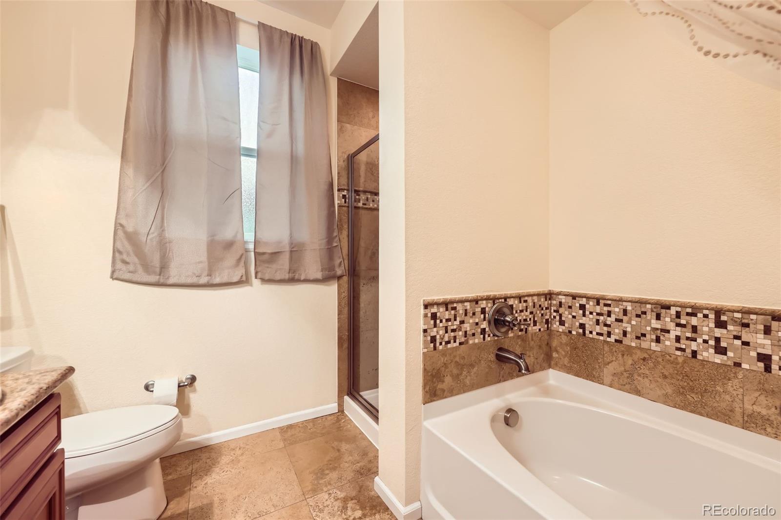 11316 Colony Circle Broomfield, CO 80021 - Photo 8 of 20 a bathroom with a bathtub and a toilet