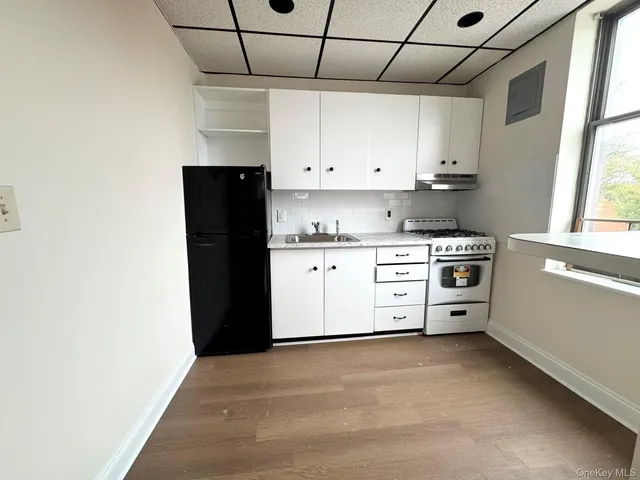 a kitchen with stainless steel appliances a stove a sink and white cabinets