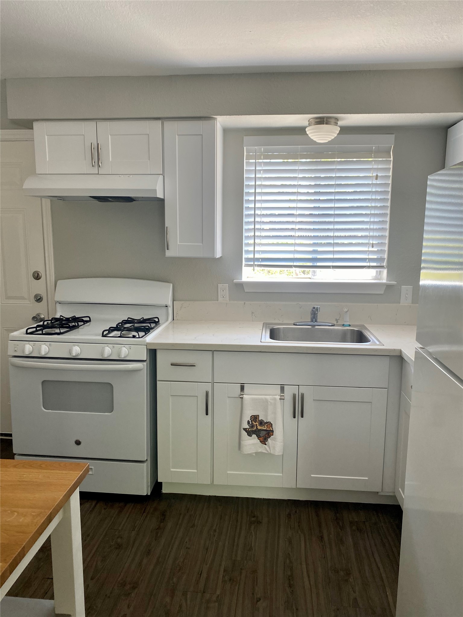 400 Swanee Drive, Unit A Austin, TX 78752 - Photo 2 of 8 a kitchen with granite countertop a stove a sink and a microwave