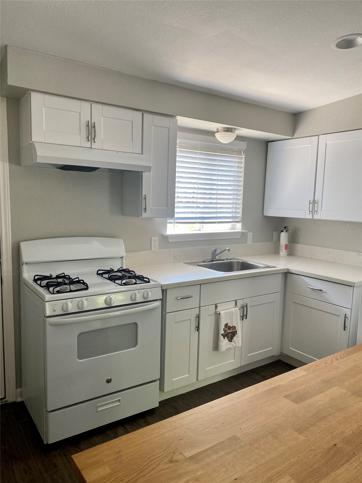400 Swanee Drive, Unit A Austin, TX 78752 - Photo 3 of 8 a kitchen with granite countertop white cabinets and stainless steel appliances
