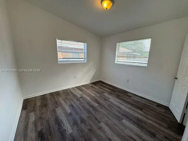 a view of a room with wooden floor and windows