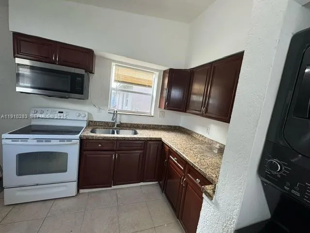 a kitchen with a sink stove and microwave