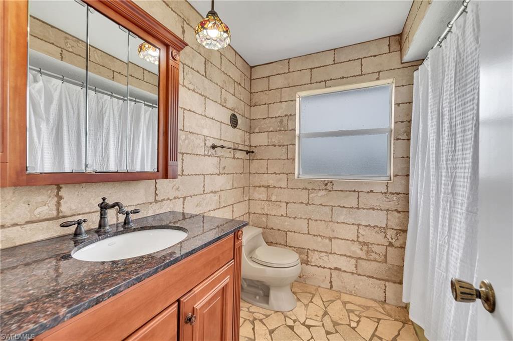 3065 50th Lane Southwest Naples, FL 34116 - Photo 19 of 31 a bathroom with a granite countertop sink toilet and mirror