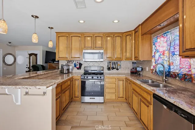 a large kitchen with stainless steel appliances granite countertop a stove sink and cabinets