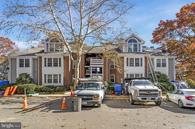 a front view of a building with cars parked