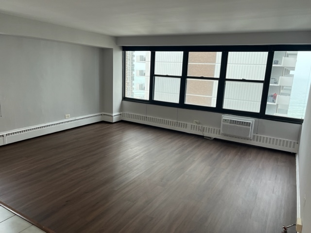 6030 North Sheridan Road, Unit 1712 Chicago, IL 60660 - Photo 11 of 28 an empty room with wooden floor and windows