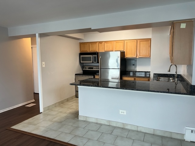 6030 North Sheridan Road, Unit 1712 Chicago, IL 60660 - Photo 12 of 28 a kitchen with stainless steel appliances a refrigerator and a sink