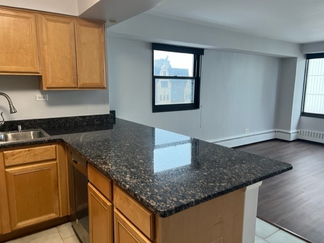 6030 North Sheridan Road, Unit 1712 Chicago, IL 60660 - Photo 4 of 28 a kitchen with granite countertop a sink a stove and cabinets