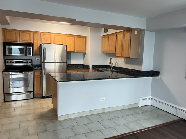 6030 North Sheridan Road, Unit 1712 Chicago, IL 60660 - Photo 5 of 28 a kitchen with granite countertop a refrigerator and a sink