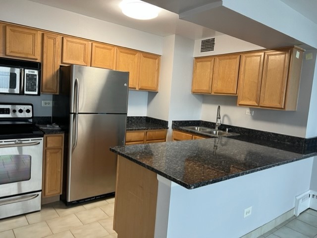 6030 North Sheridan Road, Unit 1712 Chicago, IL 60660 - Photo 6 of 28 a kitchen with refrigerator and cabinets