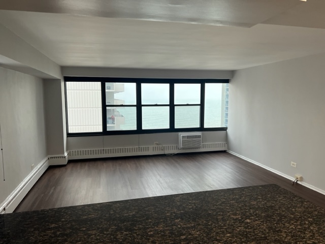 6030 North Sheridan Road, Unit 1712 Chicago, IL 60660 - Photo 8 of 28 an empty room with wooden floor and windows